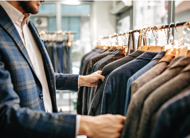 Man browsing sport coats on a clothing rack