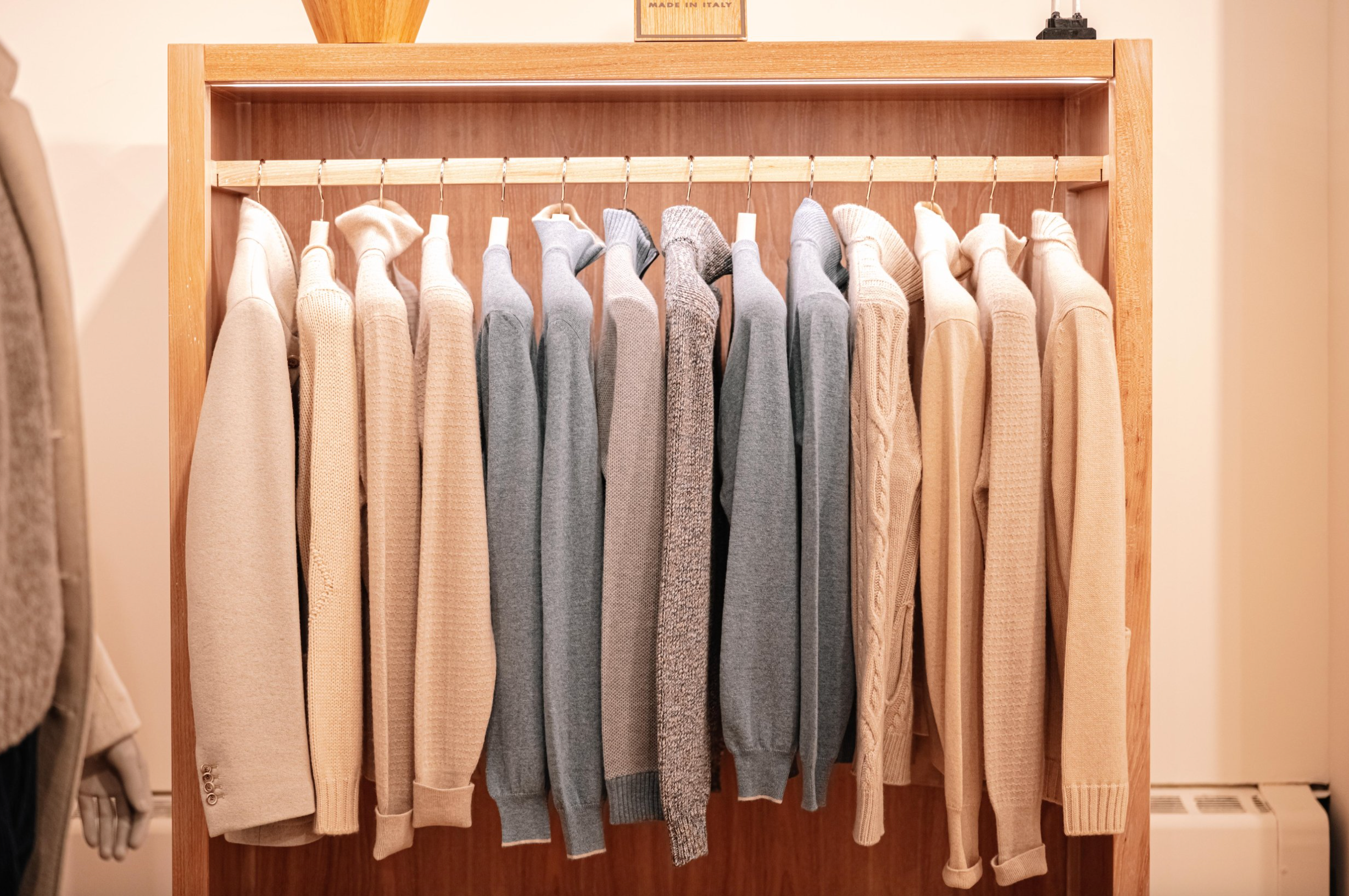 mens sweaters hanging on clothing rack in store