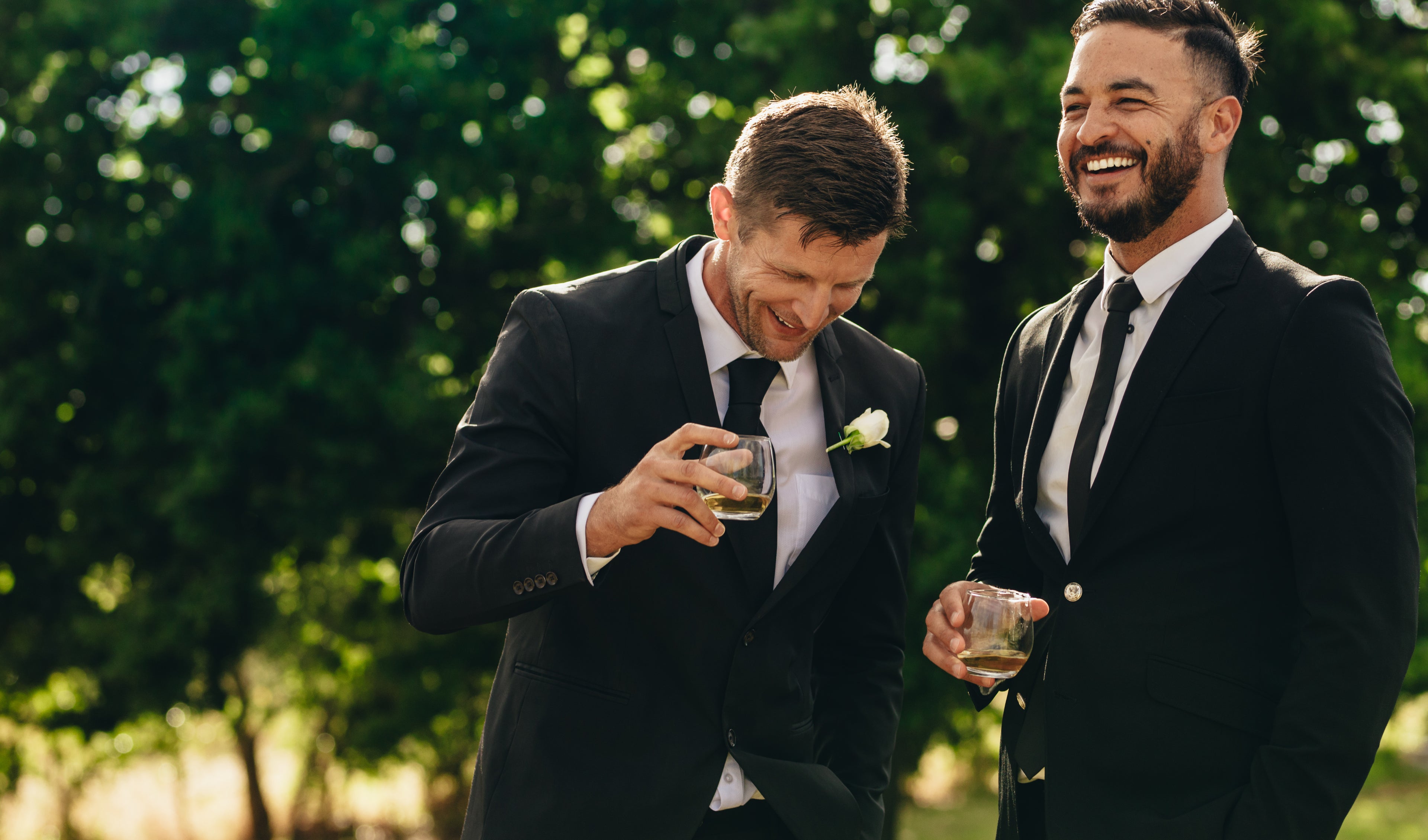 Image of two groomsmen in formal suits laughing